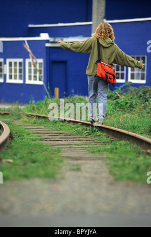 Woman balancing on a train track in Vancouver, British Columbia. Stock Photo