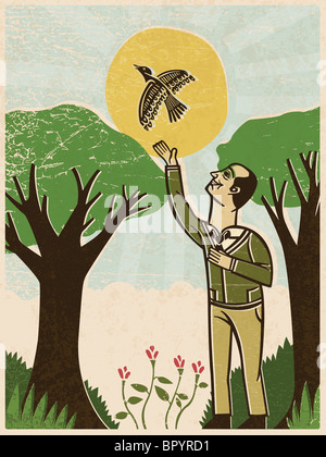 A man releasing a bird at a park Stock Photo