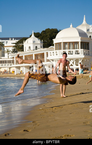 Spanish teenage boy / man practising/ practises his exercise and acrobatic skills on a sandy beach at Cadiz. Spain. Stock Photo