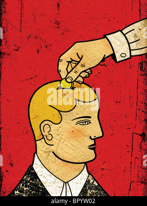 A hand putting a coin into a mans head as though he were a piggy bank Stock Photo