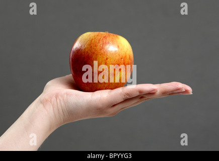 A person holds a fresh red Apple in her hand Stock Photo
