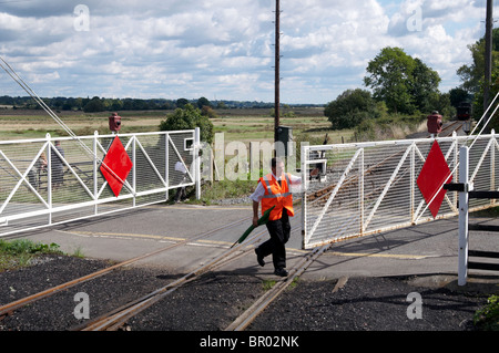 Manned level crossing at Bodiam station on the Kent & East Sussex Railway with modern safety signs and systems in use. Stock Photo