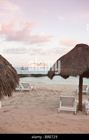 Mexico, Cozumel. Umbrellas on Beach and Cruise ship, San Miguel, Isla Cozumel, Cozumel Island. Stock Photo