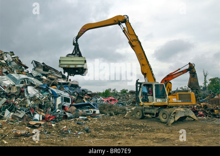 Car being unloaded on a pile in a metal scrap yard. Stock Photo