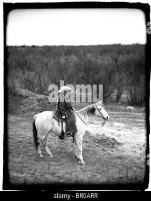 A young female cowboy on a white horse in the desert. (Polaroid) Stock Photo