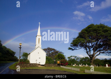 Tsunami warning system siren, church, cemetery and rainbow on the Pacific island of Molokai, Hawaii. Stock Photo