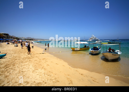 Water Taxis and luxury yachts sit off of medano Beach in Cabo San Lucas in Baja, Mexico. Stock Photo