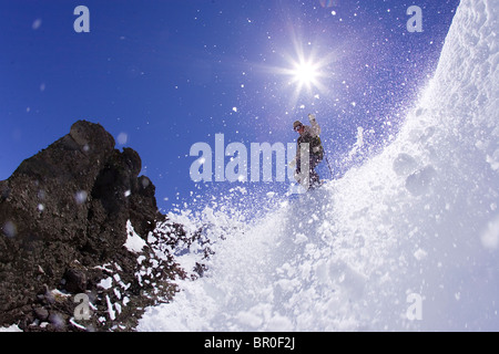 Young man dropping into couloir at Kirkwood ski resort near Lake Tahoe, CA. Stock Photo