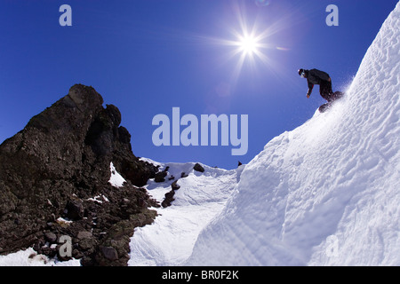 Young man dropping into couloir at Kirkwood ski resort near Lake Tahoe, CA. Stock Photo