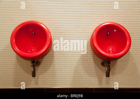 Two red urinals in the male toilets, the Virgin V Room, Gatwick airport UK Stock Photo