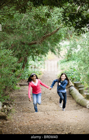Three girls holding hands and running Stock Photo - Alamy
