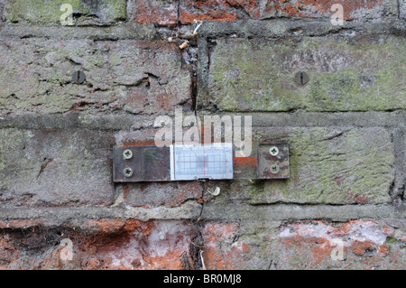 A tell-tale placed across a structural crack in brickwork to measure any change or worsening over time Stock Photo