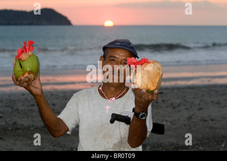 Man selling tropical drinks on the beach at sunset in the Manuel Antonio National Park in Puntarenas province, Costa Rica. Stock Photo