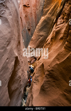 Two people canyoneering in slot canyon, Utah. Stock Photo