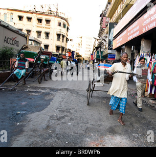 A man pulling a rickshaw is a common scene in Kolkata, India. Stock Photo