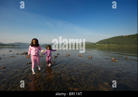 Two children playing in the water Ullswater Lake District UK