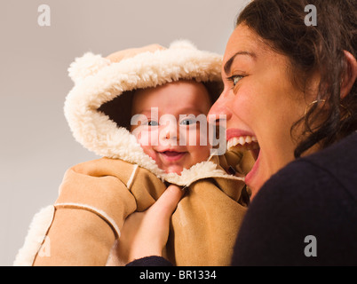 Mother holding newborn baby in winter coat Stock Photo