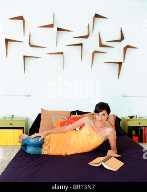 Woman reading book in bed Stock Photo
