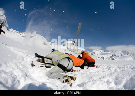 Skiers prepare to load helicopter while skiing in backcountry of southeast Alaska near Haines. Stock Photo