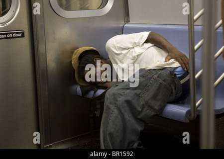 Man sleeps on a New York City subway train. Stock Photo