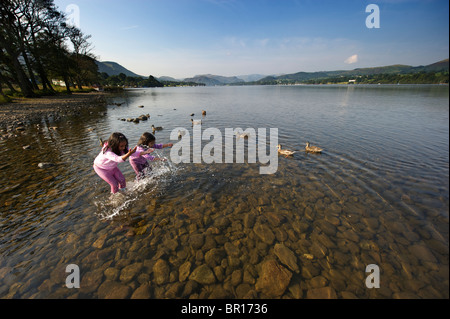 Two children playing in the water Ullswater Lake District UK