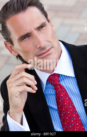 An outdoor portrait of handsome middle aged man or businessman dressed in a smart suit, shirt and tie Stock Photo