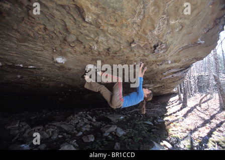 A female rock climber bouldering on an overhang near Jasper, Arkansas. Stock Photo