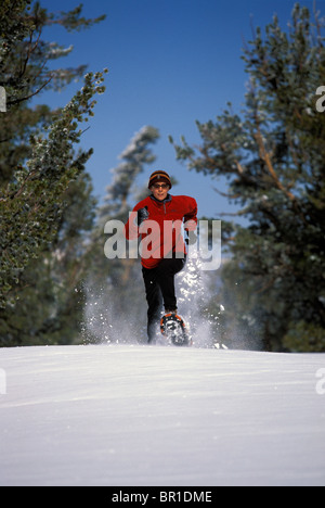 A woman running on snowshoes in Lake Tahoe, California. Stock Photo