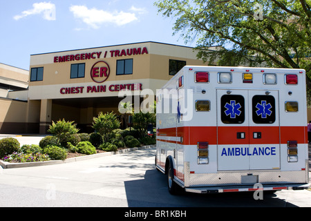 An ambulance pulls into a modern hospital emergency room entrance. Stock Photo