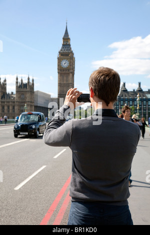 Tourist takes photo of Big Ben using smart phone, London Stock Photo