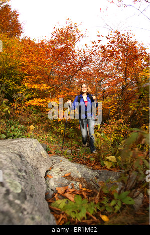 Motion-blur image of young female hiking the Mountains-to-Sea trail under fall colors near Mt. Mitchell north of Asheville, NC Stock Photo