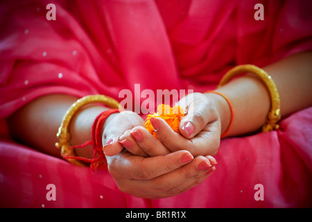 An Indian girl holds flowers in her hands during a Hindu wedding ceremony in New Delhi in India. Stock Photo