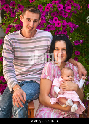 Young couple posing for portrait with baby - France. Stock Photo