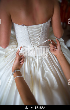 bow being tied on a wedding dress Stock Photo