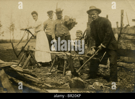 Circa 1910 photograph of a family chopping firewood. Stock Photo