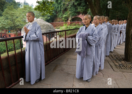 Young Buddhist nuns pray above the Dafo or Great Buddha, Le Shan, Sichuan Province, China Stock Photo