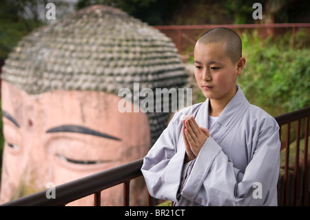 Young Buddhist nun prays above the Dafo or Great Buddha, Le Shan, Sichuan Province, China Stock Photo