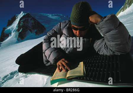 Woman reading a book in the snow in the mountains in Chamonix, France. Stock Photo