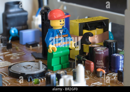 Lego workman with giant spanner on an electronic circuit board Stock Photo