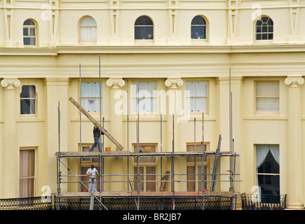 The Georgian buildings of Brunswick Square are repainted every 5 years. Scaffolders at work. Hove, East Sussex, England Stock Photo