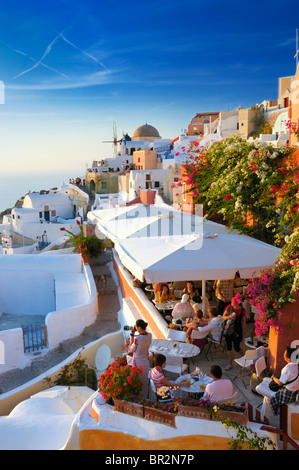 Tourists wait for the sunset in a restaurant in Oia, Santorini Island, Greece. Stock Photo