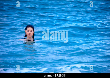 Portrait of young woman swimming in blue ocean Stock Photo