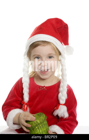 Little beautiful girl in Santa Claus hat sitting under the Christmas ...