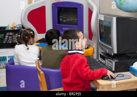 Preschool children using the computers in the classroom Stock Photo