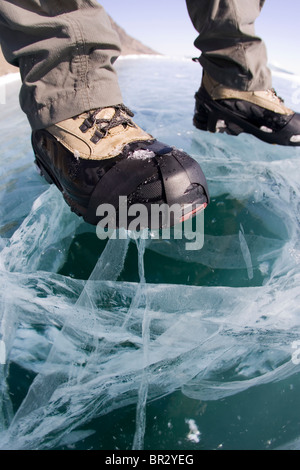 A hiker on the frozen Lake Baikal during the winter in Siberia, Russia. Stock Photo