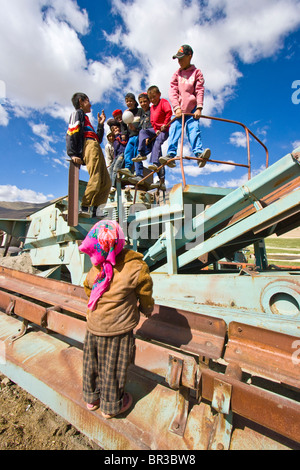 Children playing on rusted old equipment in Bulunkul in the Pamirs, Tajikistan Stock Photo