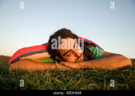 Man inside sleeping bag on the coast of Maine, New England. Stock Photo