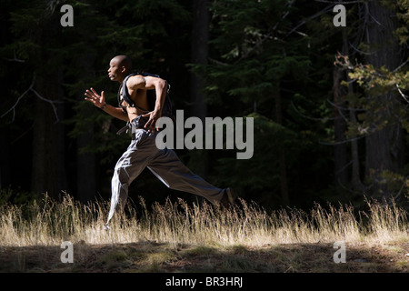 African American man, Cupid Alexander, runs on trail near Mt. Hood in the Cascade Mountains, Oregon. (high contrast) Stock Photo