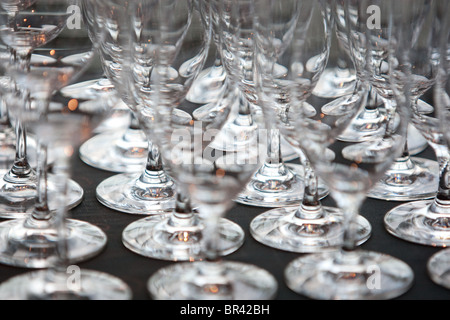 rows of wine glasses on black surfaced table top at hotel event/function Stock Photo