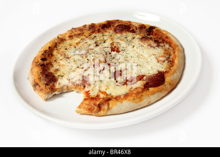 One bite missing from a Pepperoni Pizza on a white background Stock Photo